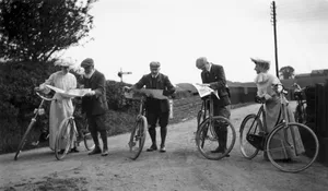 Edwardian cyclists examining old maps in a country lane Edwardian cyclists examining old maps in a country lane