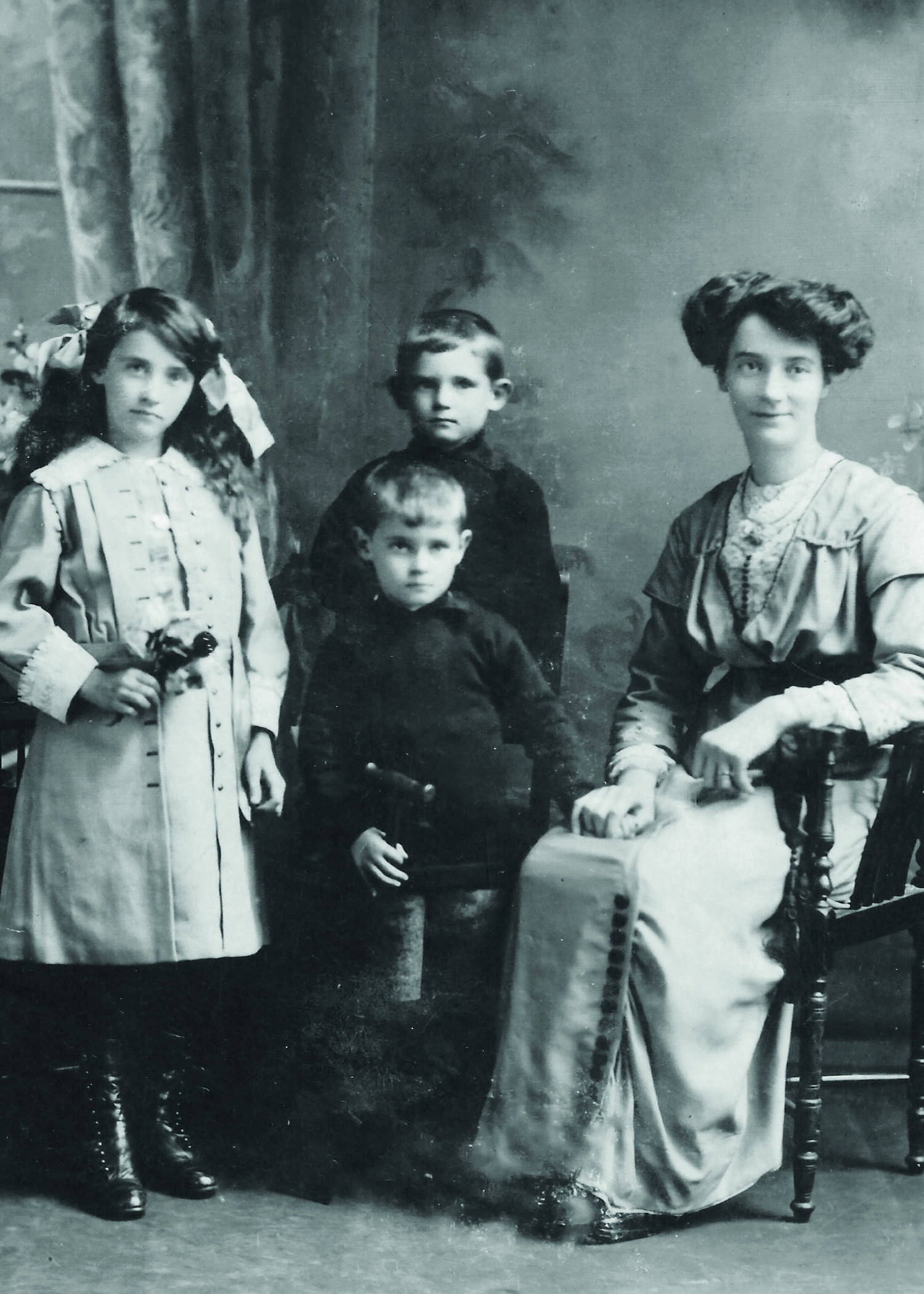 Black and white photograph of a woman, two boys and a girl in Victorian clothes