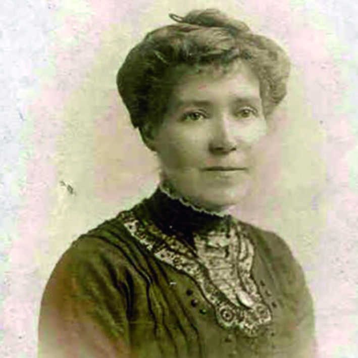 Black and white photograph of a woman in a dark blouse with her hair pinned up
