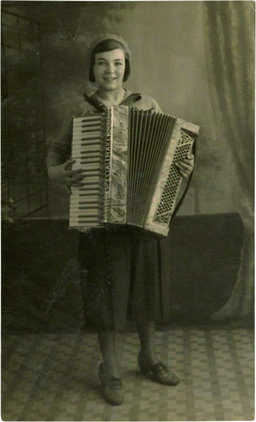 Black and white photograph of a smiling little girl playing an accordion