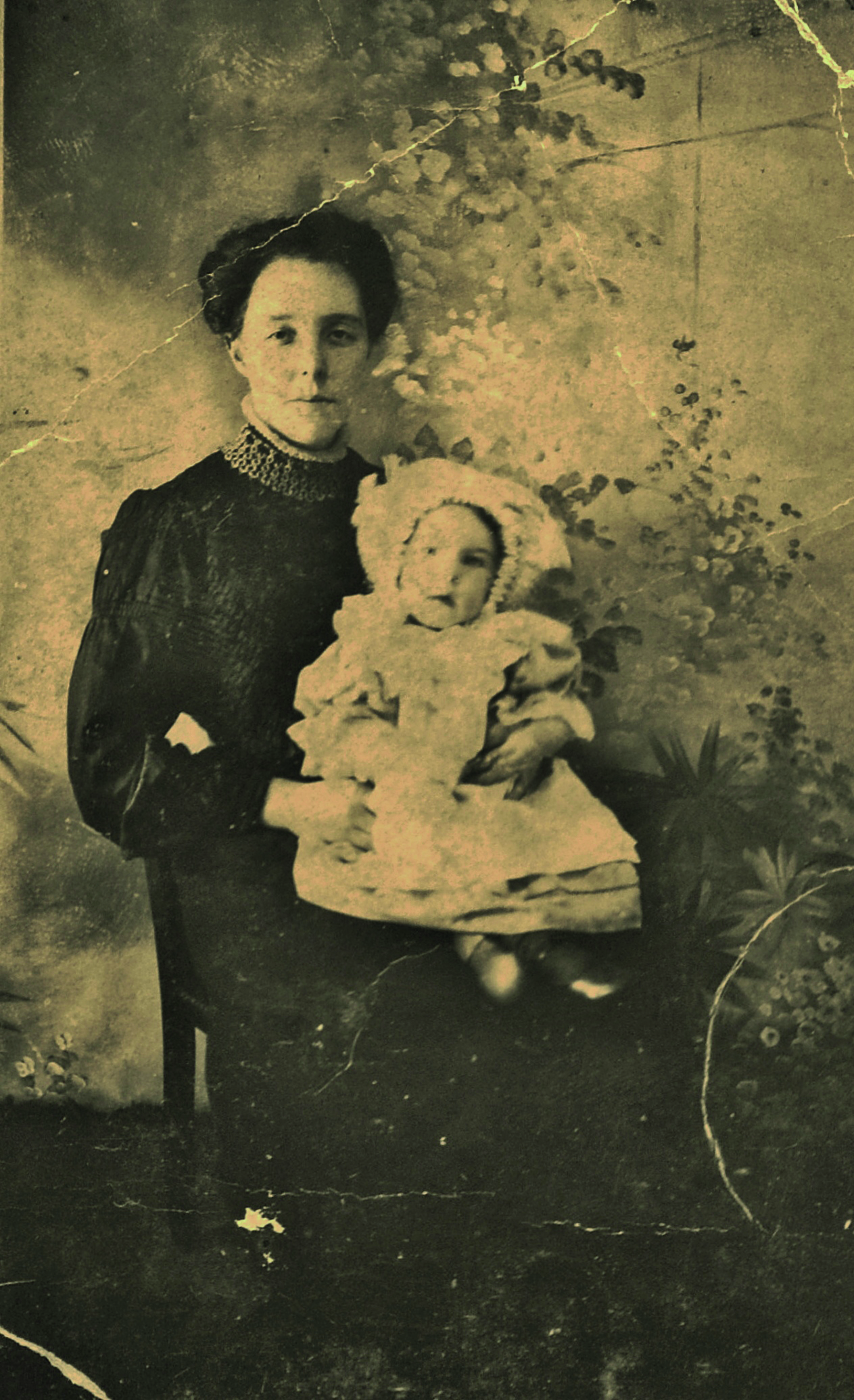 Black and white photograph of a young woman holding a baby