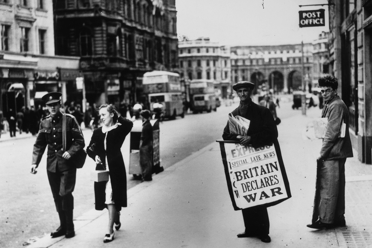Black and white photograph of a newspaper seller in London holding a hoarding saying 'Britain Declares War'